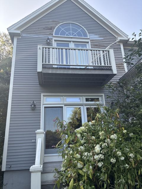Painted balcony railing and trim on a gray house