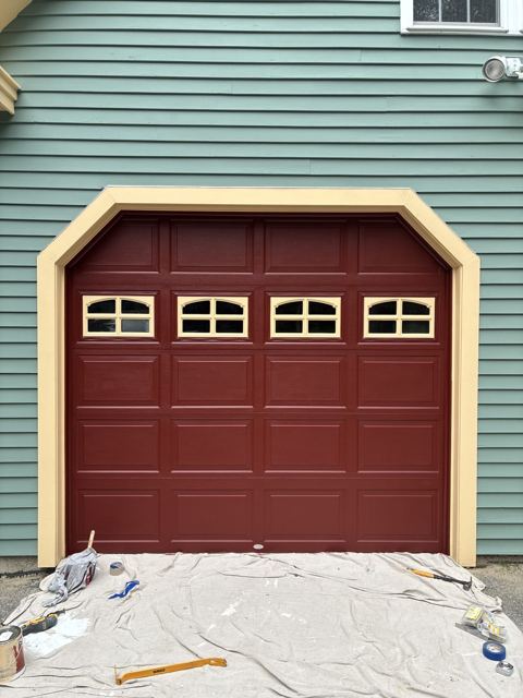 Burgundy garage door with freshly painted yellow trim