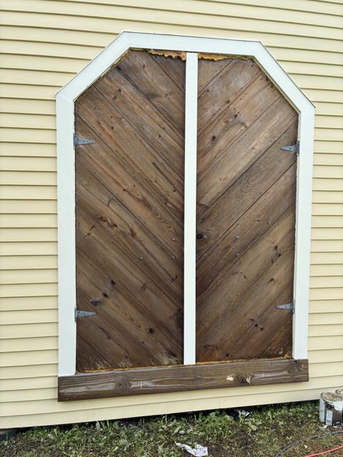 Chevron-pattern wooden doors with new white trim